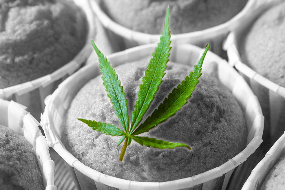 Green Marijuana Leaf on top of a black and white image of muffins