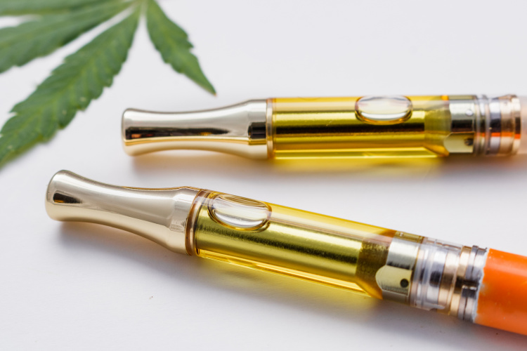 Two cannabis vape cartridges on a white background