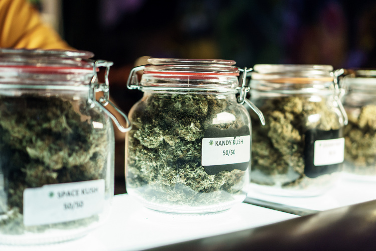 Assorted cannabis flower displayed in glass containers