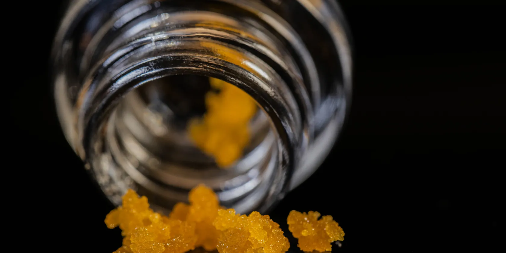 Close-up of cannabis concentrate beside glass jar