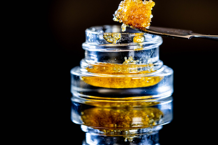 Cannabis concentrate in a glass jar with a dab tool